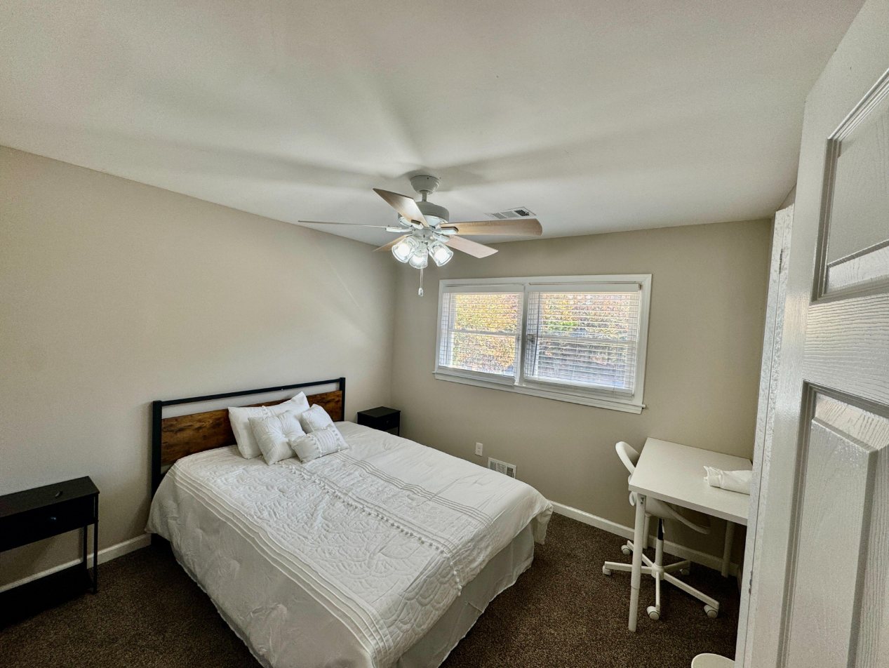 Room 3: bright bedroom with a double window, queen bed and desk
